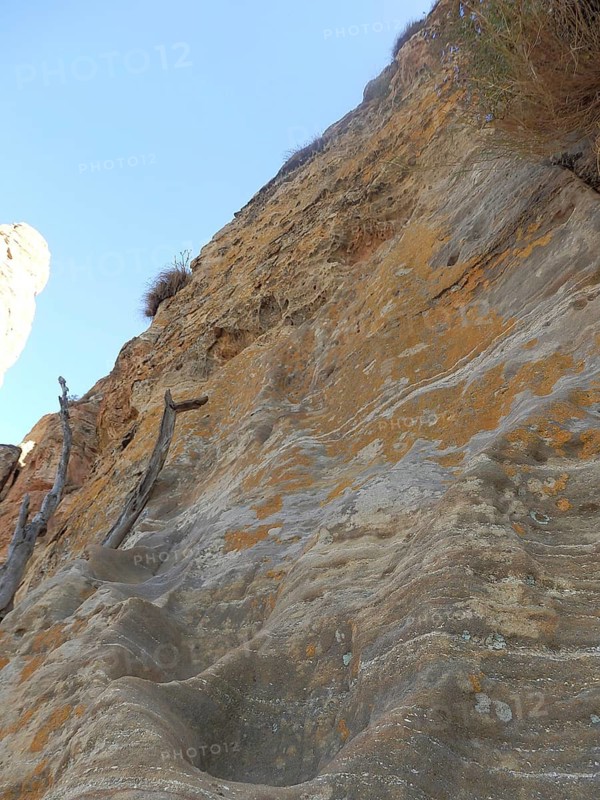 Steep climb to Abuna Yemata Guh rock church, steep rock wall with blue sky in the background, Tigray, Ethiopia