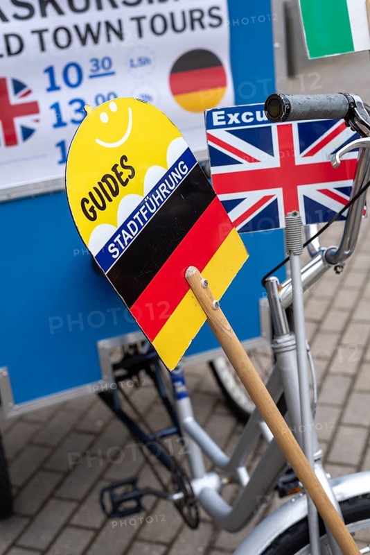 Signs with German and English flags show tourists which city tour is taking place in which language, Riga, Latvia