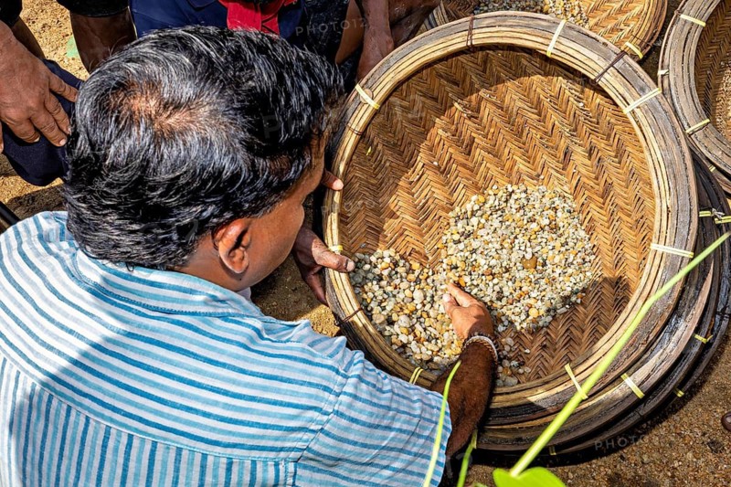 A man sorts rocks and sand in a basket, the sapphire and gemstone mines at Ratnapura in Sri Lanka