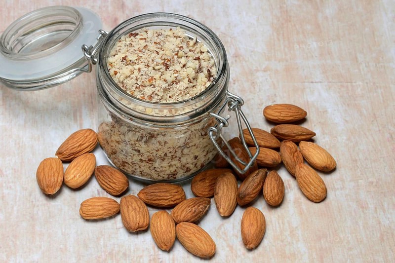 Almonds and ground almonds in glass, Prunus amygdalus
