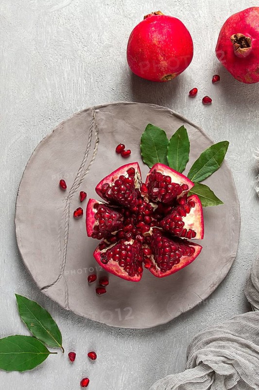 Fresh, cut pomegranate fruit, on a gray background, food concept, top view, no people