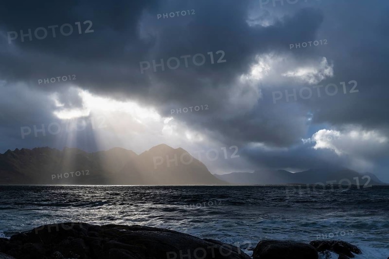 Sunbeams over coastal landscape and sea, Lofoten, Nordland, Norway, September 2020