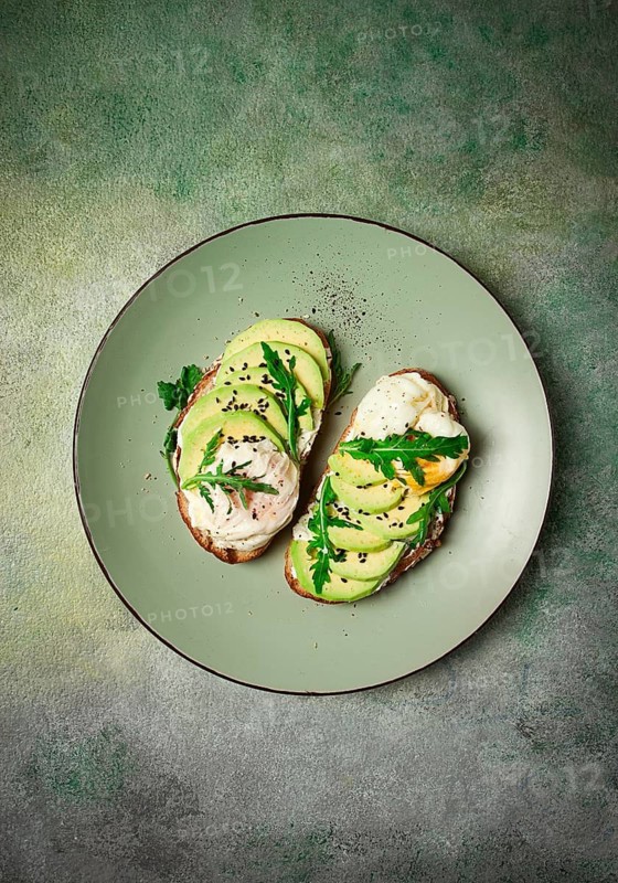 Sandwich with cream cheese, sliced avocado and boiled egg, arugula, on grainy bread, homemade, breakfast, no people