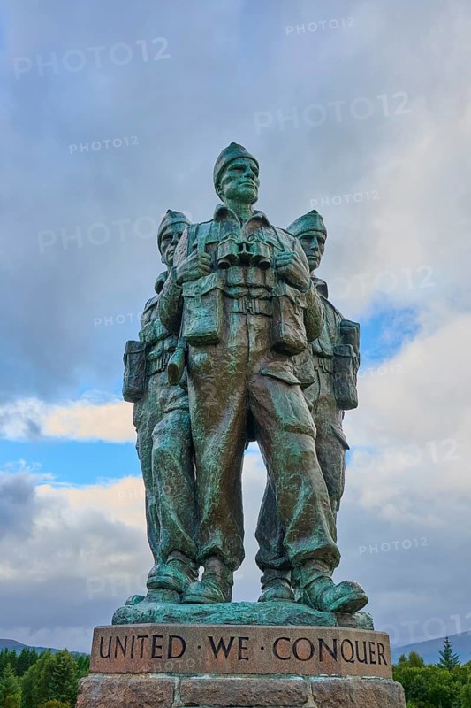 Three soldiers standing in a bronze sculpture, clouds in the sky, words 'United We Conquer', Commando Memorial, Spean Bridge, Scotland, United Kingdom, Great Britain