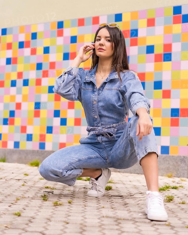 Young caucasian girl with a monkey cowboy in colored tiles. Enjoying the city on vacation, lifestyle of a young girl, crouched on the Sulo on a trendy posing