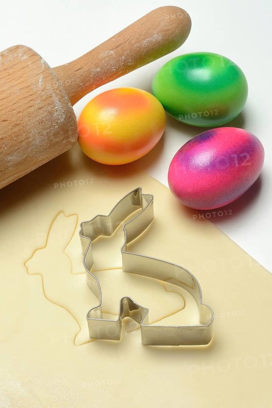 Rolled dough with bunny cookie cutter, rolling pin and Easter eggs