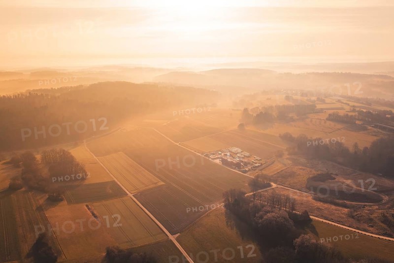 Extensive view of fields and forests, softly lit by sunrise and enveloped in fog, Gechingen, Calw district, Germany