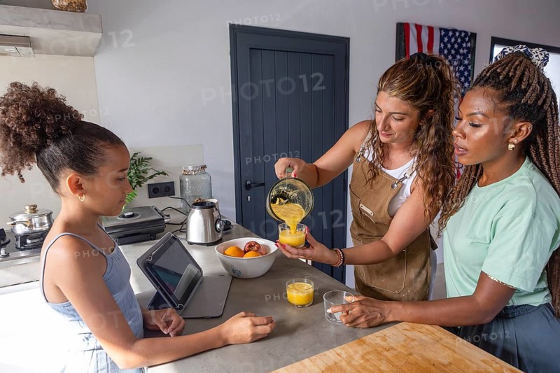 A loving lesbian family shares a sweet moment in the kitchen, preparing breakfast together. This image reflects love, unity, and the joy of simple togetherness in daily life