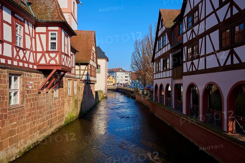 Canal between half-timbered houses, bright blue sky, historic architecture inviting and picturesque, Mümling river, Erbach, Odenwald, Hesse, Germany