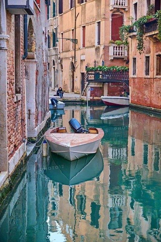View on a waterway with boats lying in the water in Venice on a sunny day in winter, Italy