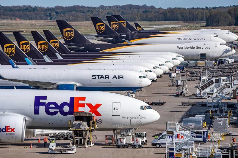 FedEx Express Boeing 777-FS2 cargo plane is unloaded, air freight container, behind cargo fleet of Star Air, Maersk and UPS cargo aircraft, air freight center at Cologne/Bonn airport, North Rhine-Westphalia, Germany