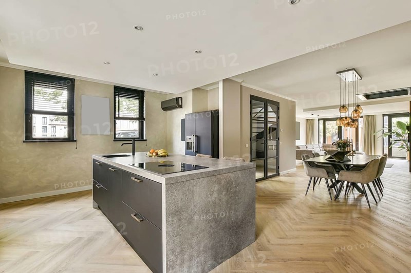 Stylish modern kitchen featuring an island countertop, elegant dining area, and light-colored walls that create a spacious and inviting atmosphere