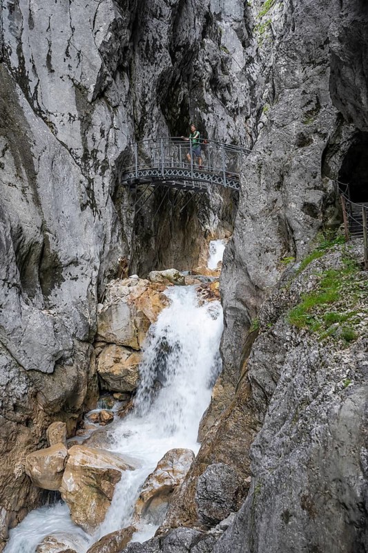 Mountaineer on a bridge over the mountain stream Hammersbach in a gorge, Höllentalklamm, Höllental, Bavaria, Germany