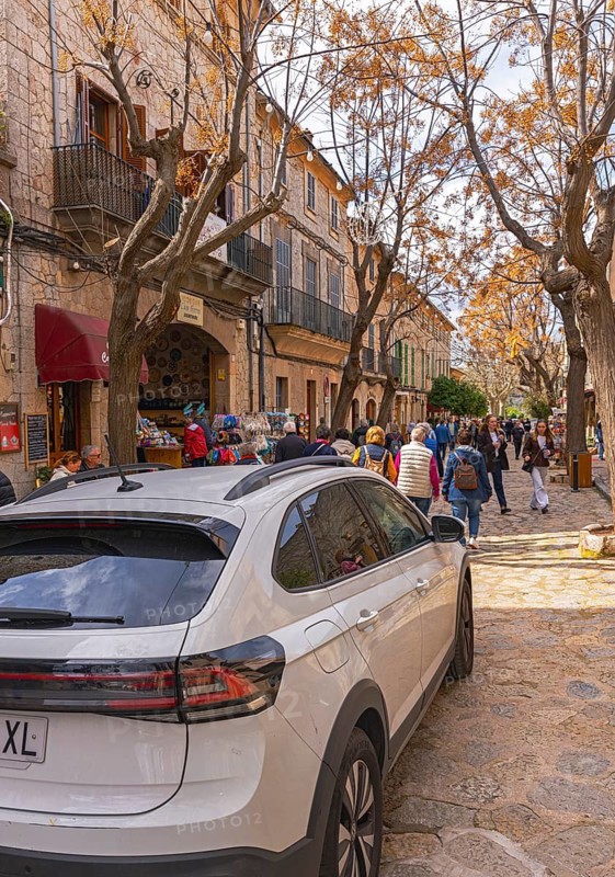 Vehicle crosses the shopping street in the small mountain village of Valdemossa, Majorca, Balearic Islands, Spain