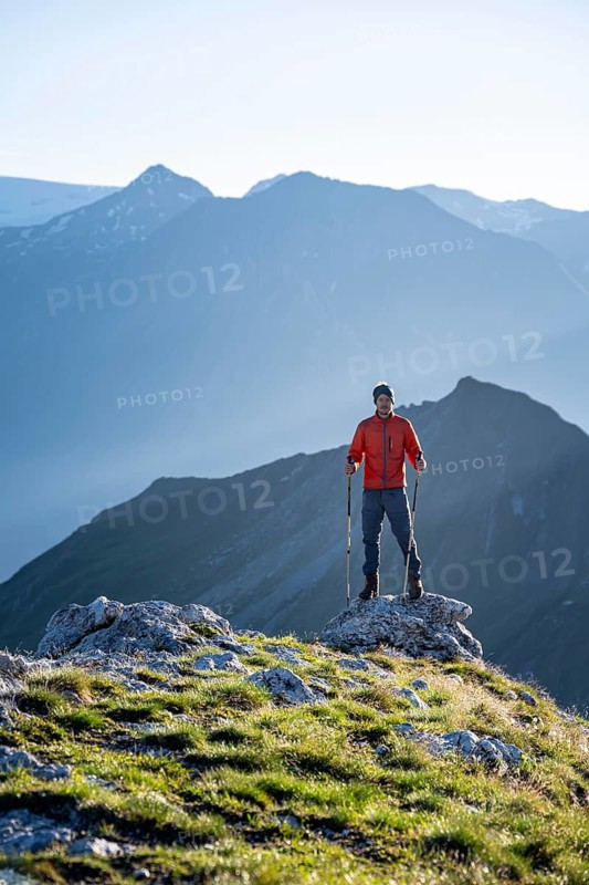 Hiker enjoying the mountain panorama in the morning, Venediger group, behind Dreiherrenkopf, Simonysitze and Großer Geiger, Hohen Tauern, Austria