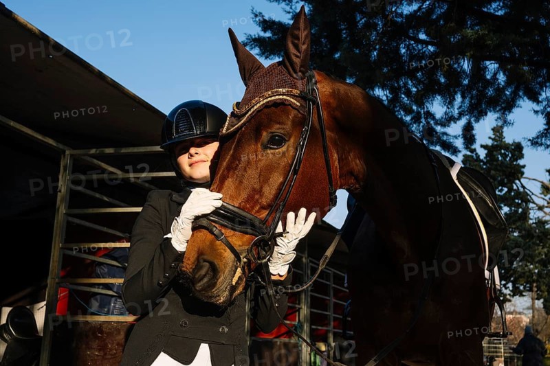 A rider in elegant dressage attire affectionately embraces a horse The scene captures a serene moment of connection after a training session in a classical dressage setting