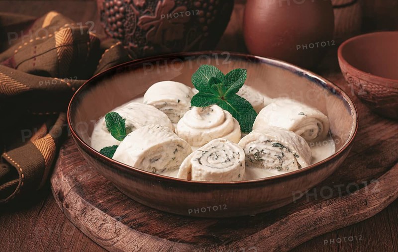 Gebjalia, a traditional Georgian dish, cold appetizer of cheese with mint, Megrelian cuisine, on a wooden table, homemade. no people