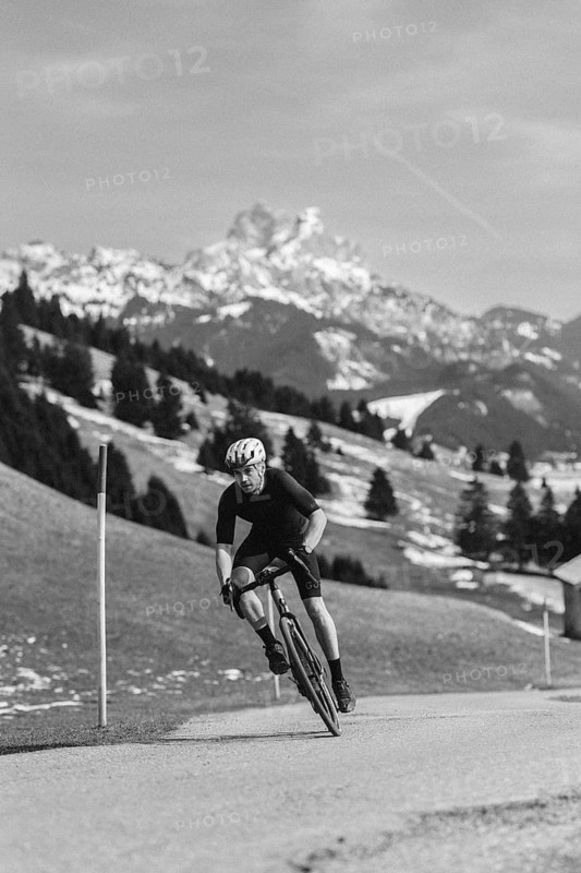 Road bike rider in spring in the Allgäu against the picturesque backdrop of the Alps, Bavaria, Germany