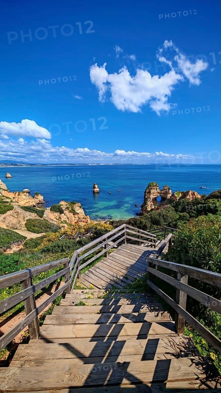 Wooden staircase leads to breathtaking views of rock arches, coastal cliffs and the sea, Praia do Camilo, Lagos, Algarve, Portugal