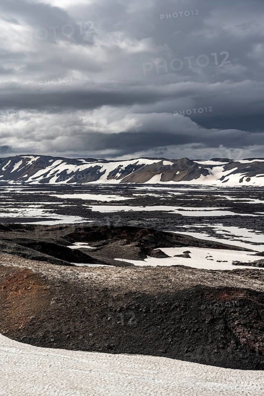 Snow-covered volcanic landscape with volcanic sand and petrified lava, crater of Askja volcano, Icelandic highlands, Iceland