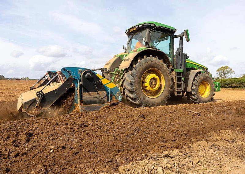 John Deere 8R 340 tractor engaged in field work operating an Agri-World FTC series soil tiller, Shottisham, Suffolk, England, UK
