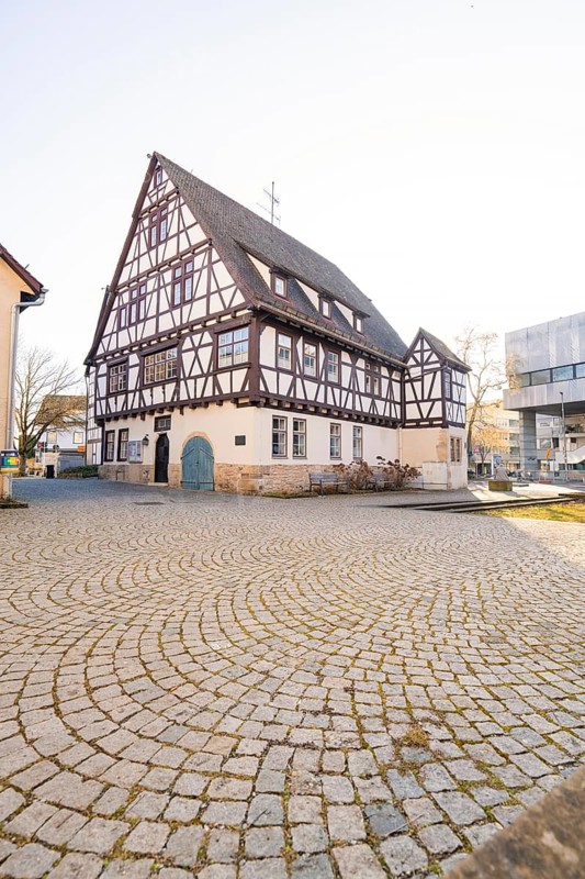 Large half-timbered house on a cobbled square under a clear sky, Sindelfingen, Böblingen district, Germany
