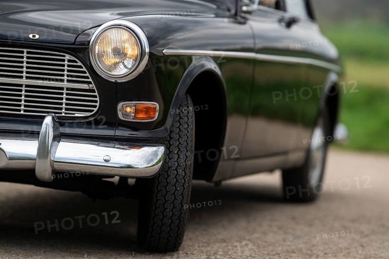Front round front light and front section, vintage car, black Volvo Amazon, medium class car from Swedish car manufacturer Volvo, built in 1968