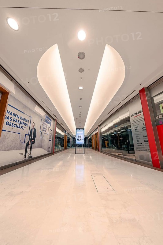 Empty illuminated corridor in a modern shopping centre with bright ceiling structure, Stuttgart, Germany