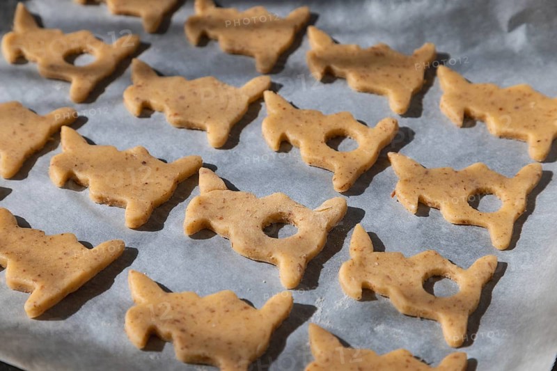Unbaked cookies in the shape of Easter bunnies on baking paper ready for baking