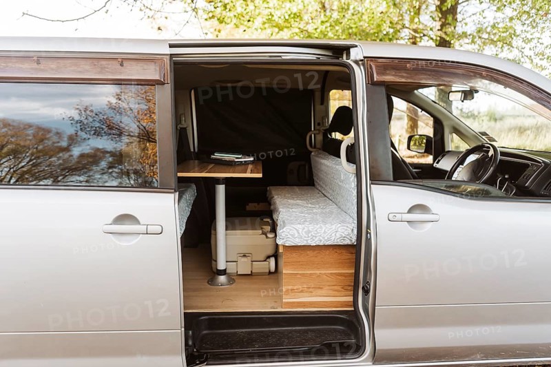 Serene lifestyle of living in a van amid New Zealand autumn. Enjoying the cozy setup with rustic views, surrounded by vibrant fall foliage and peaceful nature