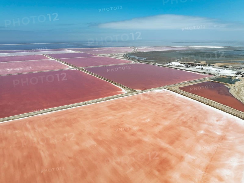 Saline ponds and salt heaps at the salt works of Walvis Bay Salt. Aerial view. Drone shot. Walvis Bay, Namibia