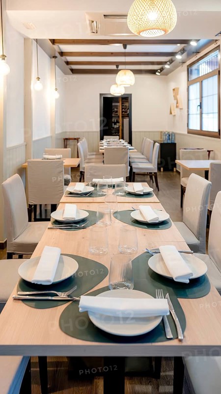 Elegant restaurant interior featuring neatly arranged tables with elegant dinnerware, soft lighting, and comfortable seating, creating a cozy and inviting dining ambiance