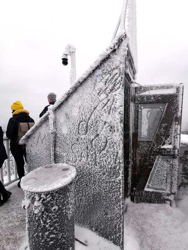 Snowy and icy spire from the Asenturm am Ochsenkopf with people, conveys an icy atmosphere, hiking in the Fichtelgebirge nature park Park