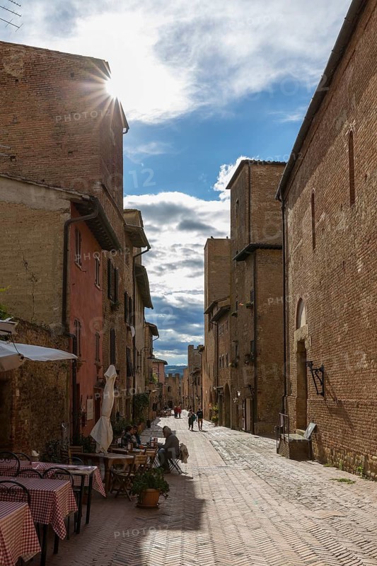 Via Giovanni Boccaccio, the main street with historic buildings and street restaurants in the historic centre of Certaldo, Tuscany, Italy