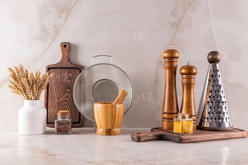 Elegant kitchen utensils arranged on a marble countertop reflecting modern interior design trends