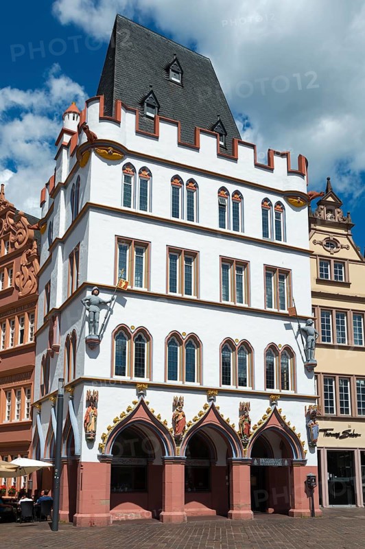 White historic building with red decorations and medieval charm in the city, Haus Steipe with arcade and battlements, Hauptmarkt, Trier, Rhineland-Palatinate, Germany