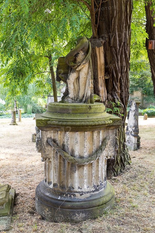 Old grave figure on a column, without head, Riesa cemetery, Saxony, Germany