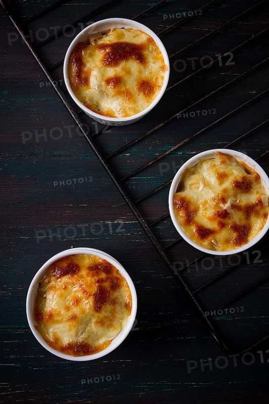 Julienne with mushrooms and cheese, in white ceramic cups, homemade, top view, no people
