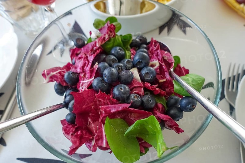 Vegetarian cuisine, salad with blueberries, radicchio (Cichorium intybus var. foliosum), glass bowl, salad servers, table setting, dining table, arranged, healthy, food photography, studio, Germany