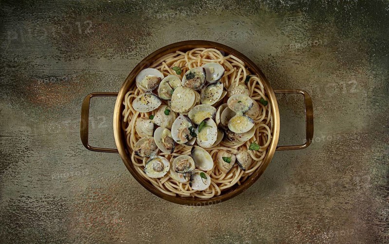 Spaghetti with vongole clams, in cream sauce, carbonara, in a brass pan, homemade, top view, no people