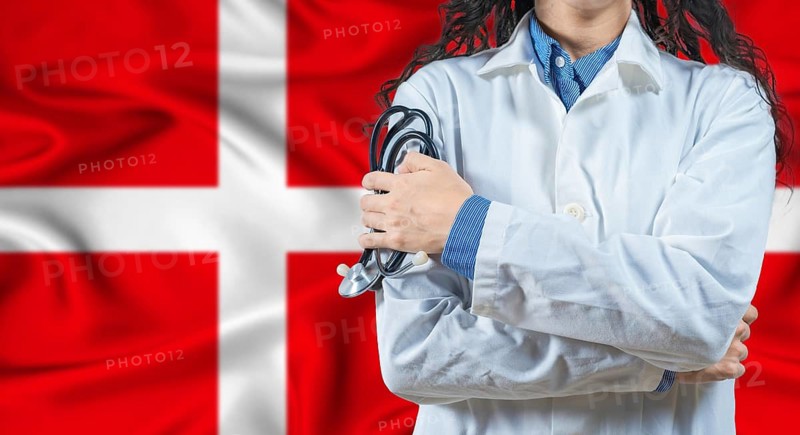 Healthcare professional with Denmark flag background. Professional doctor holding stethoscope on Denmark flag background