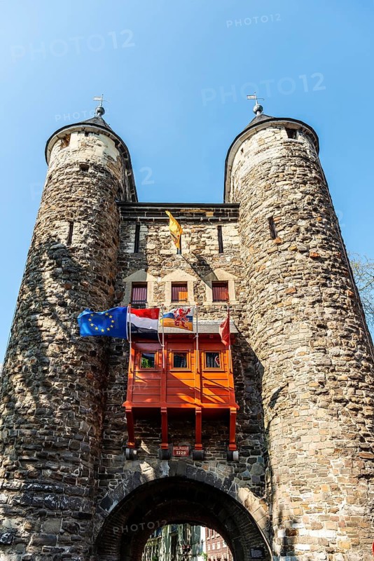 Maastricht, Netherlands, The Helport, A medieval city gate with towers, decorated with flags, stretches into the sky