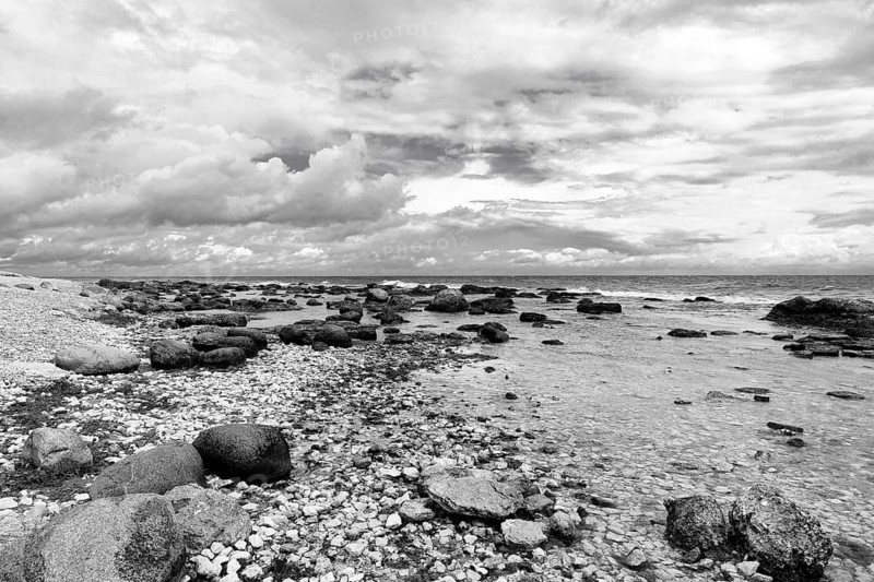 Characteristic coastline, wild natural beach, boulders, dramatic cloudy sky, monochrome, film set, Holmudden, Fårö island, Gotland, Baltic Sea, Sweden
