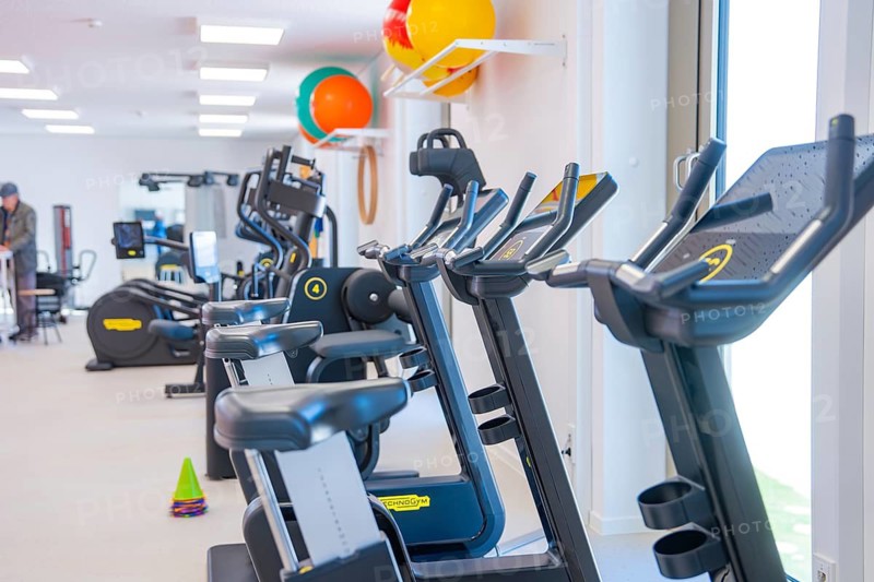 Row of modern treadmills in gym with colorful balls in the background, medical center in the new health campus, Calw, Germany