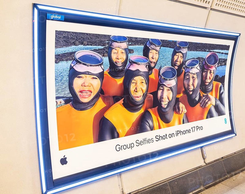 Advertising poster for Group Selfies Shot on iPhone 17 Pro, Transport for London (TfL) underground train station, London, England, UK