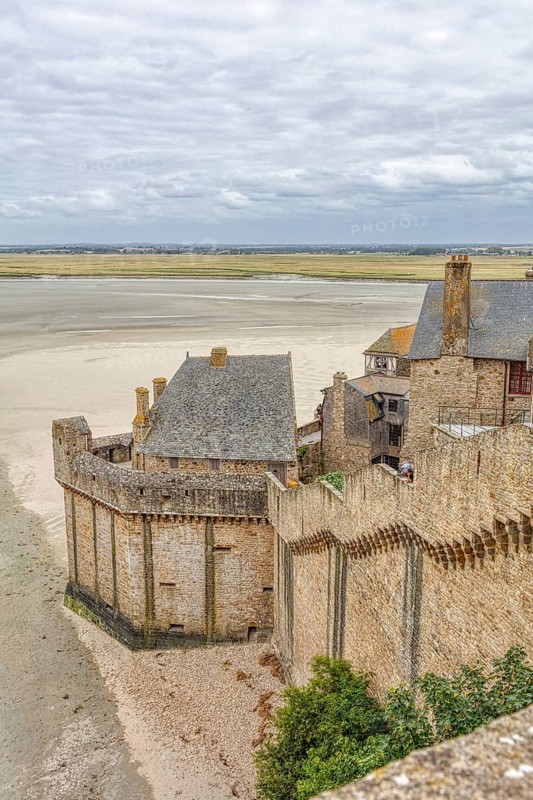 View from above of Mont Saint-Michel in a wide coastal landscape with sand and sea, Le Mont-Saint-Michel