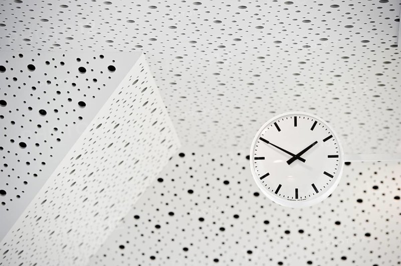 Black and white clock on a black and white ceiling, symbol of time