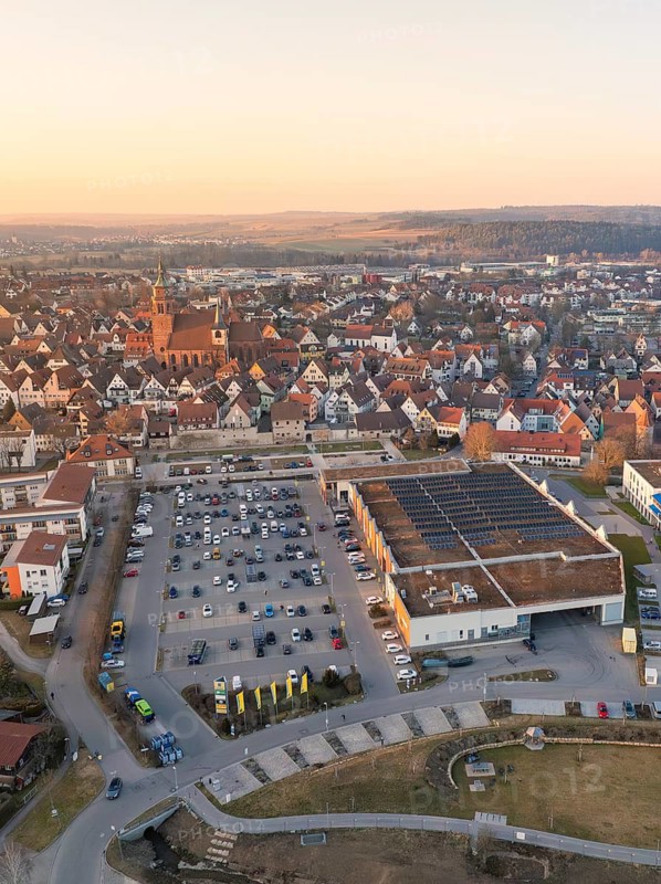 Town view with many white roofs, church tower and a car park in the evening light, Weil der Stadt, Böblingen district, Germany