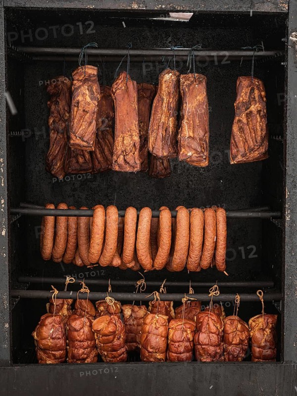 Cooked meats: bacon, ham and sausage hanging in the smoker