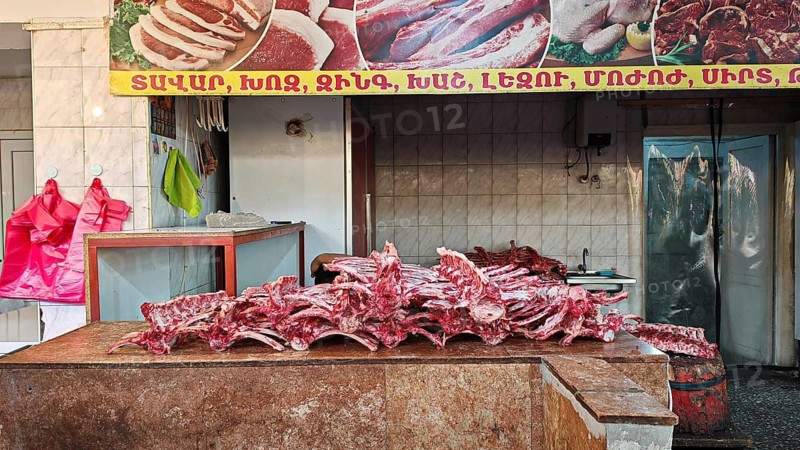 Meat sales stand at the market with various types of meat and signs, Armenia